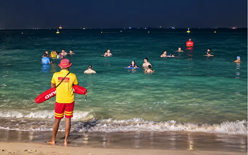 Umm Suqeim Night Swimming Beach Dubai with lifeguards and rescue support monitoring swimmers at night