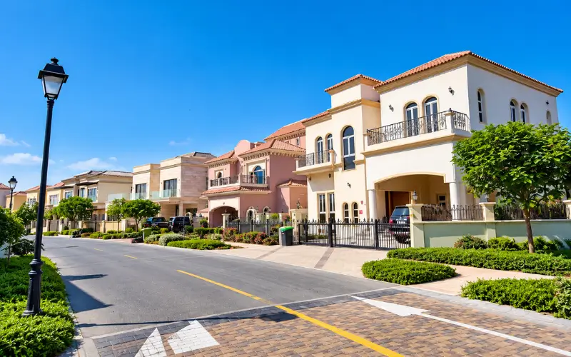 Oud Al Muteena 1 residential area with spacious villas, landscaped gardens, paved streets, and decorative streetlights.