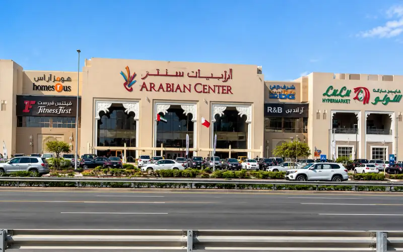 Arabian Center in Oud Al Muteena Dubai with its main entrance, shops, parking area, and surrounding road.